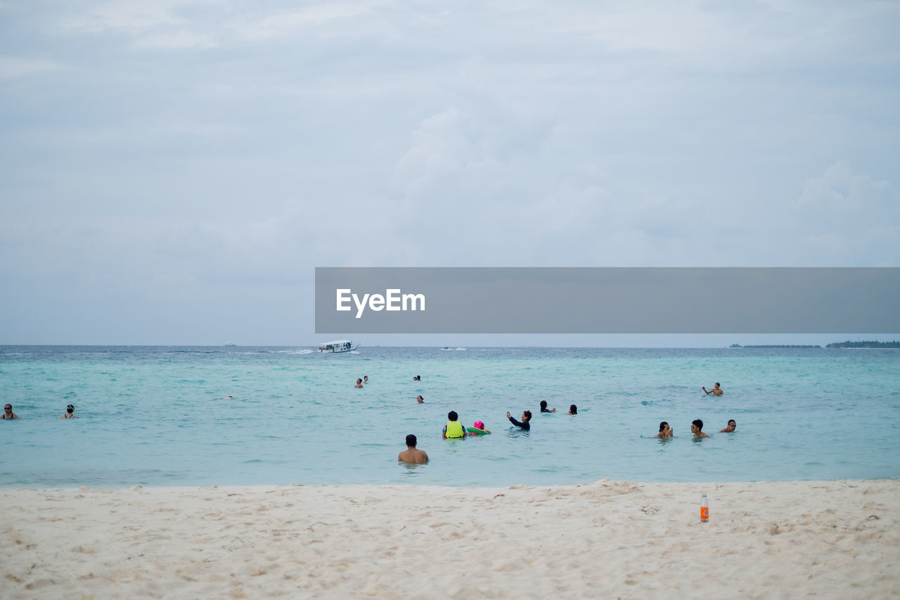 People on beach against sky