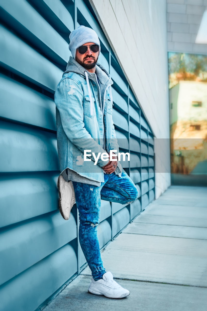 PORTRAIT OF MAN STANDING ON WALL