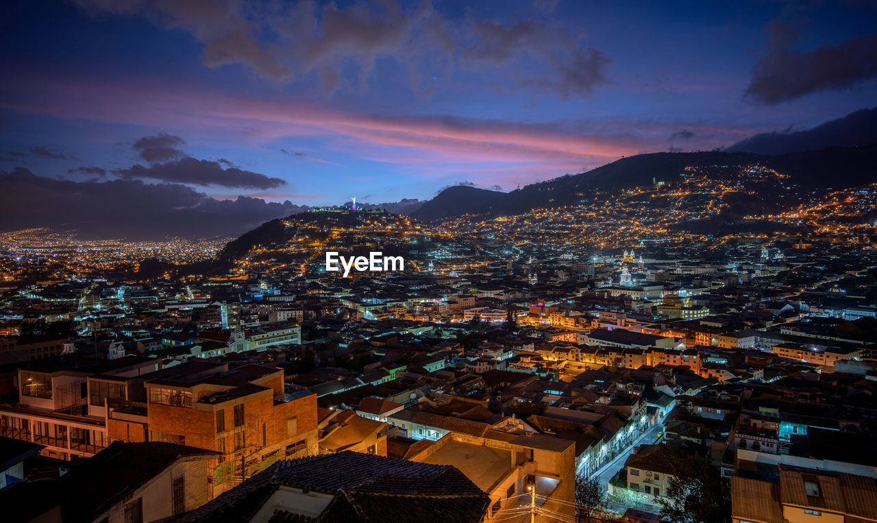 High angle view of illuminated city against sky at dusk