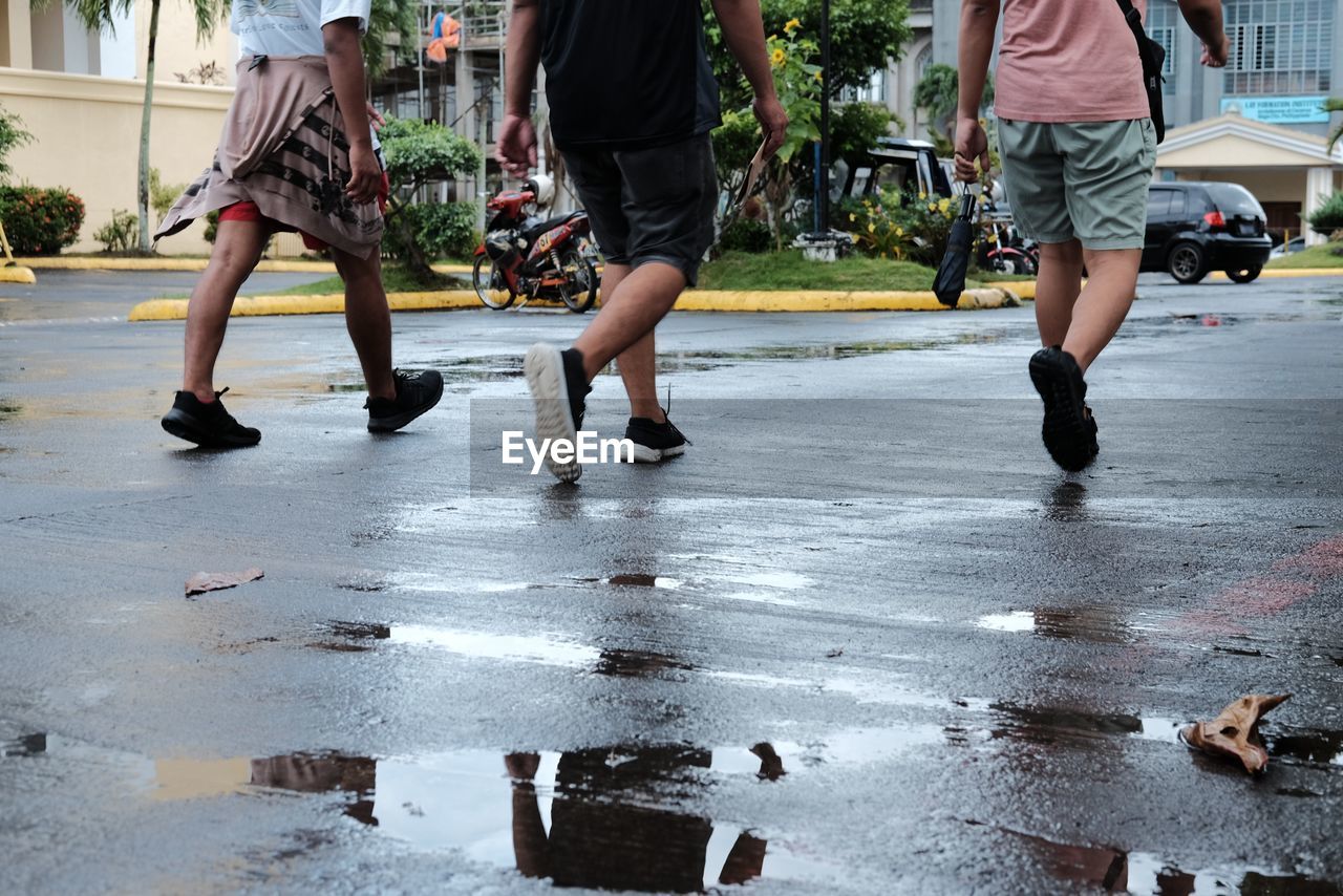 LOW SECTION OF PEOPLE WALKING ON ROAD