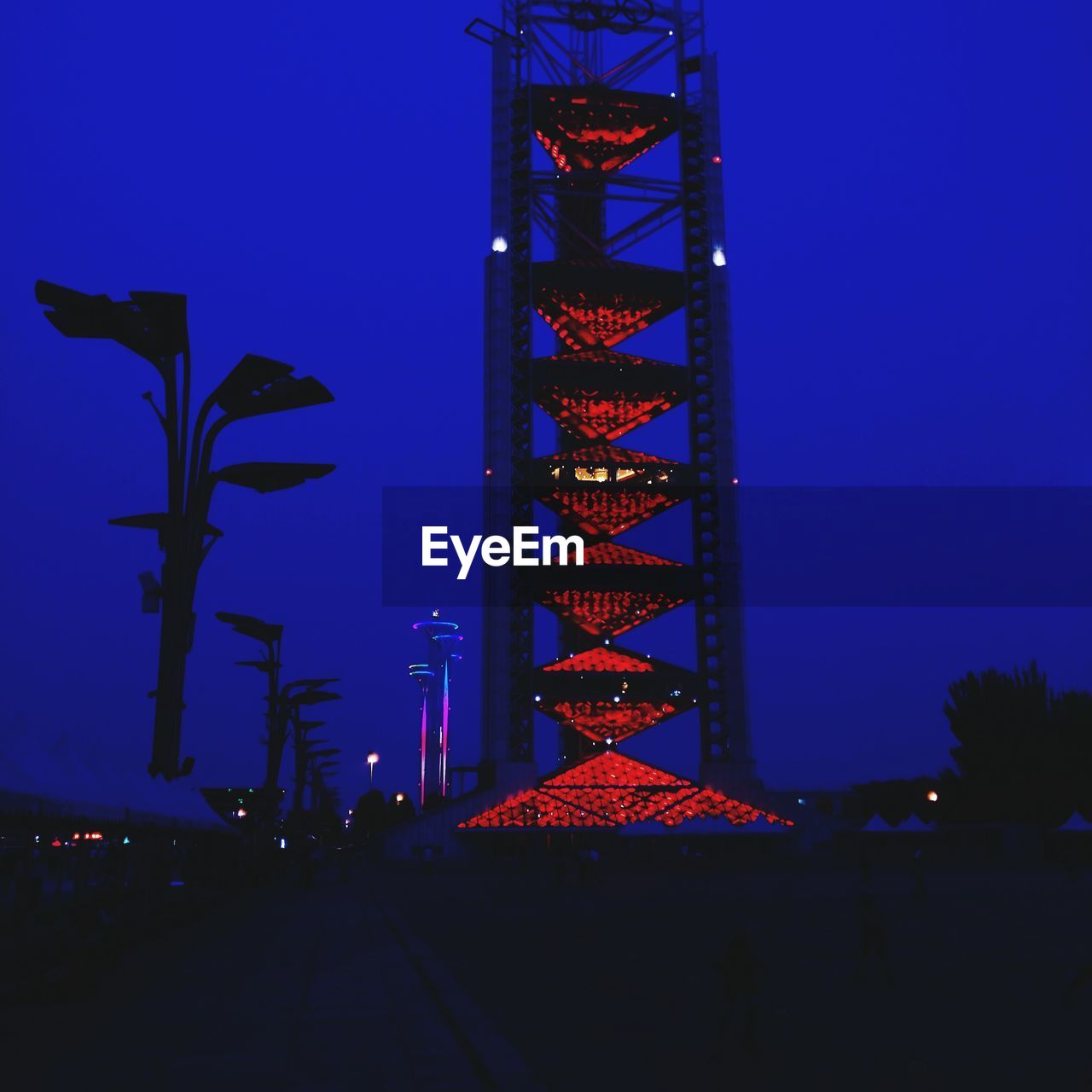 LOW ANGLE VIEW OF ILLUMINATED BUILT STRUCTURE AGAINST BLUE SKY