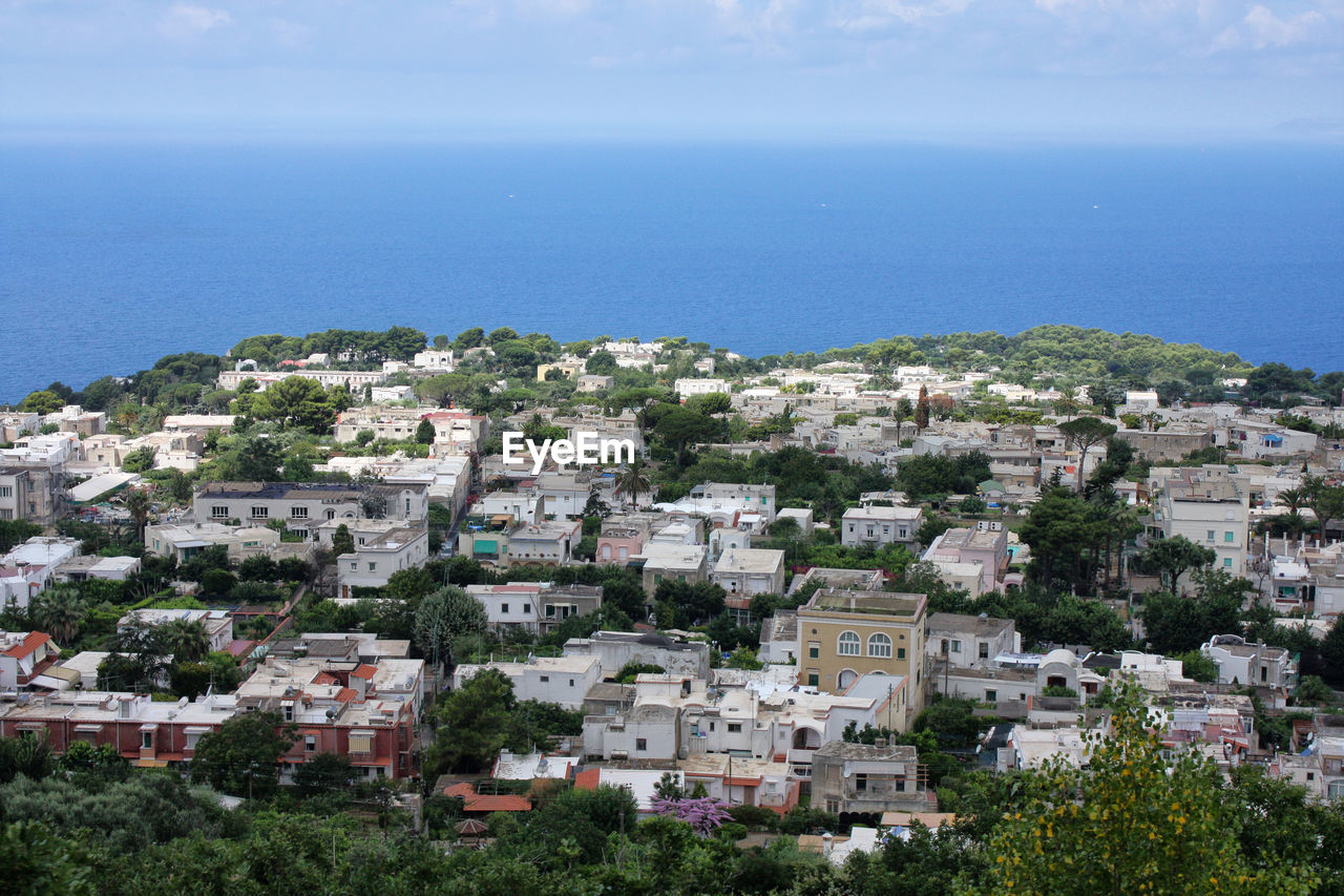 High angle view of townscape by sea against sky