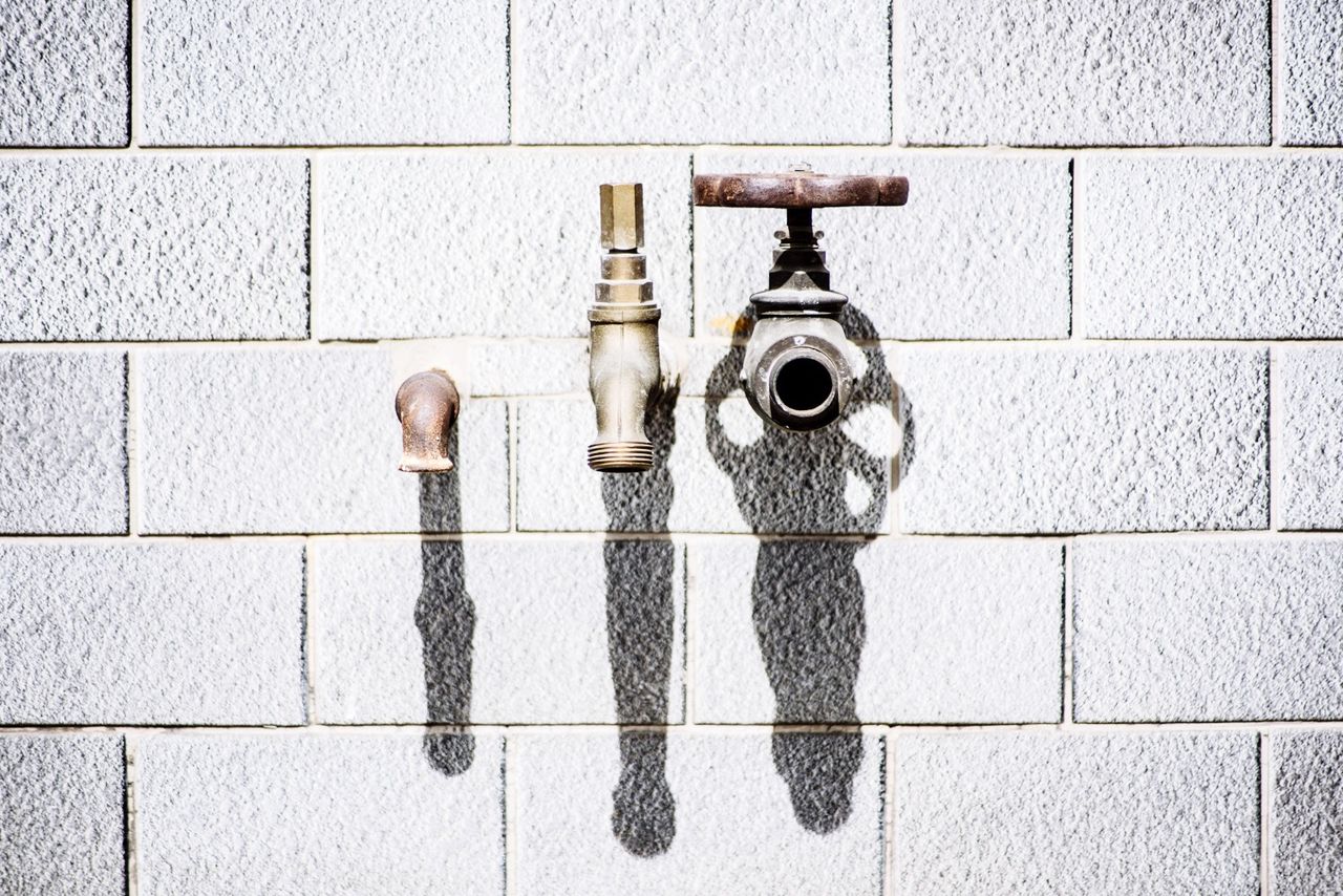 Faucets on brick wall