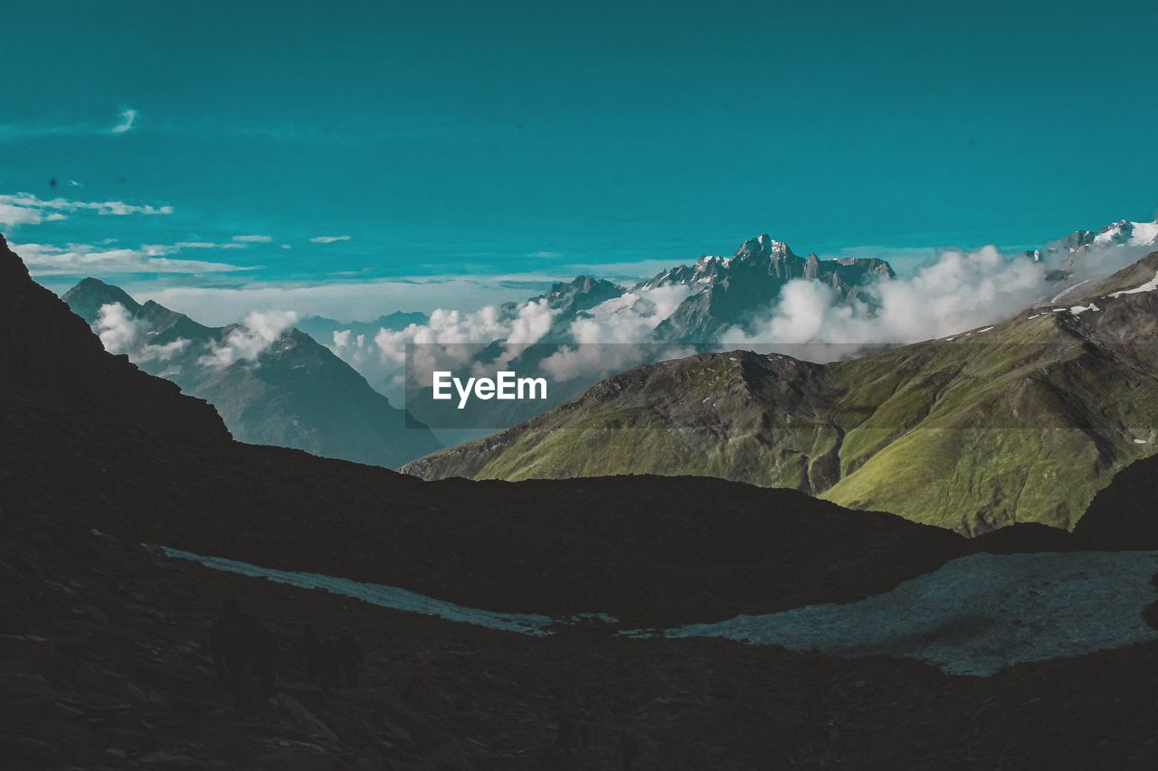 Scenic view of snowcapped mountains against blue sky