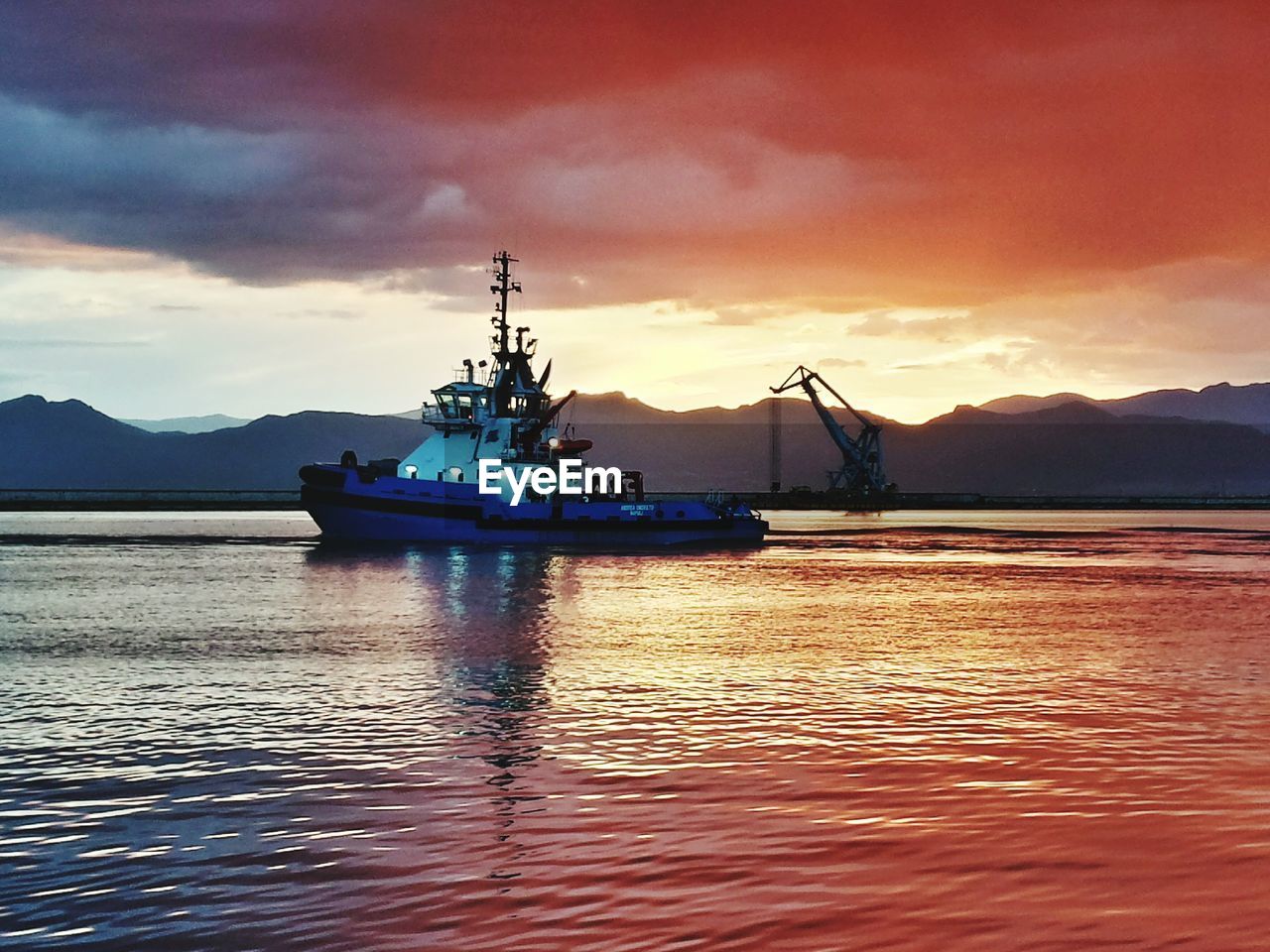 Pilot boat sailing in sea during sunset