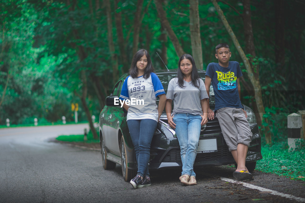 PORTRAIT OF PEOPLE SITTING ON TREE