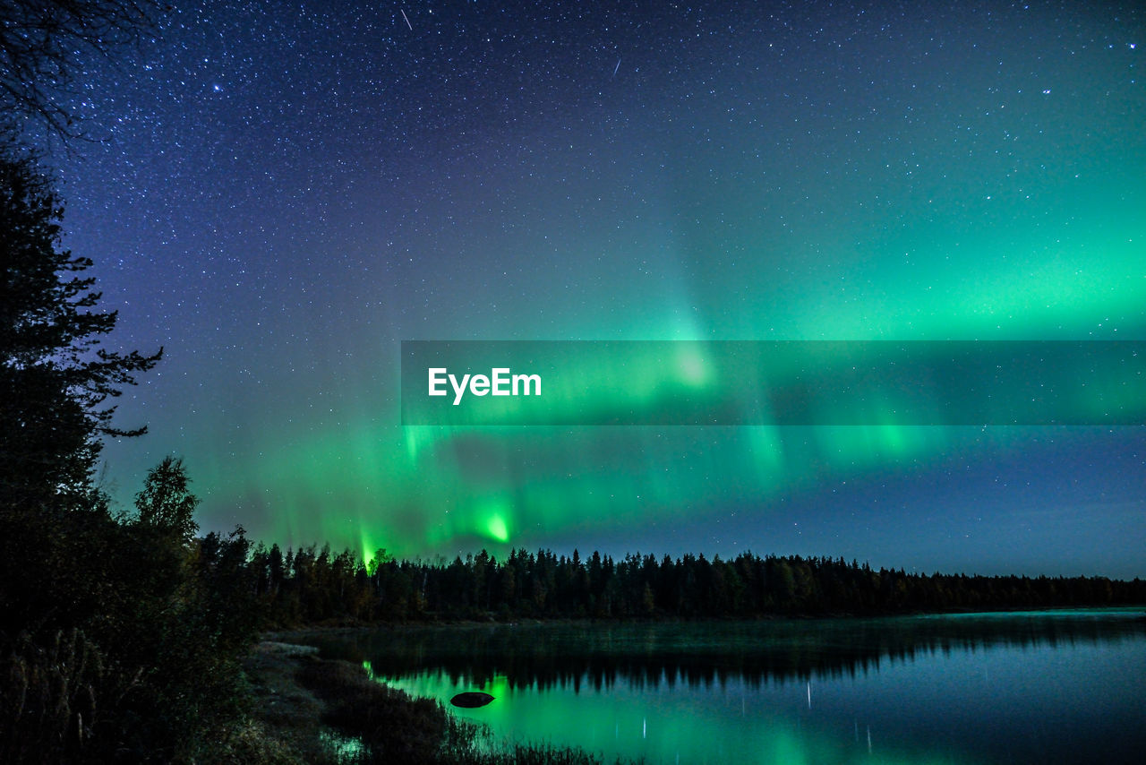 Scenic view of lake against sky at night