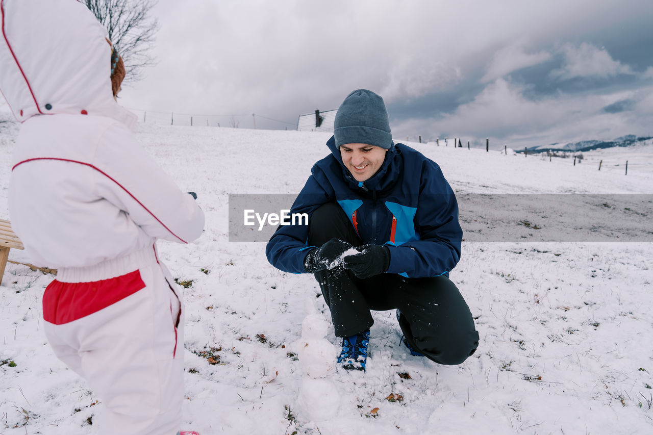 side view of man standing on snow covered field