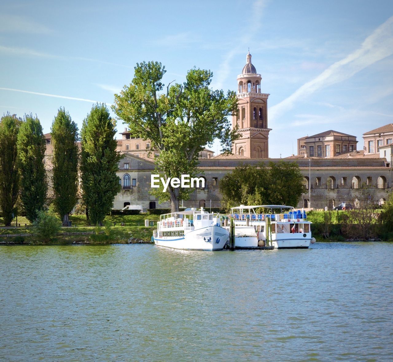 Boats on mincio lakes in front of historical buildings in mantova