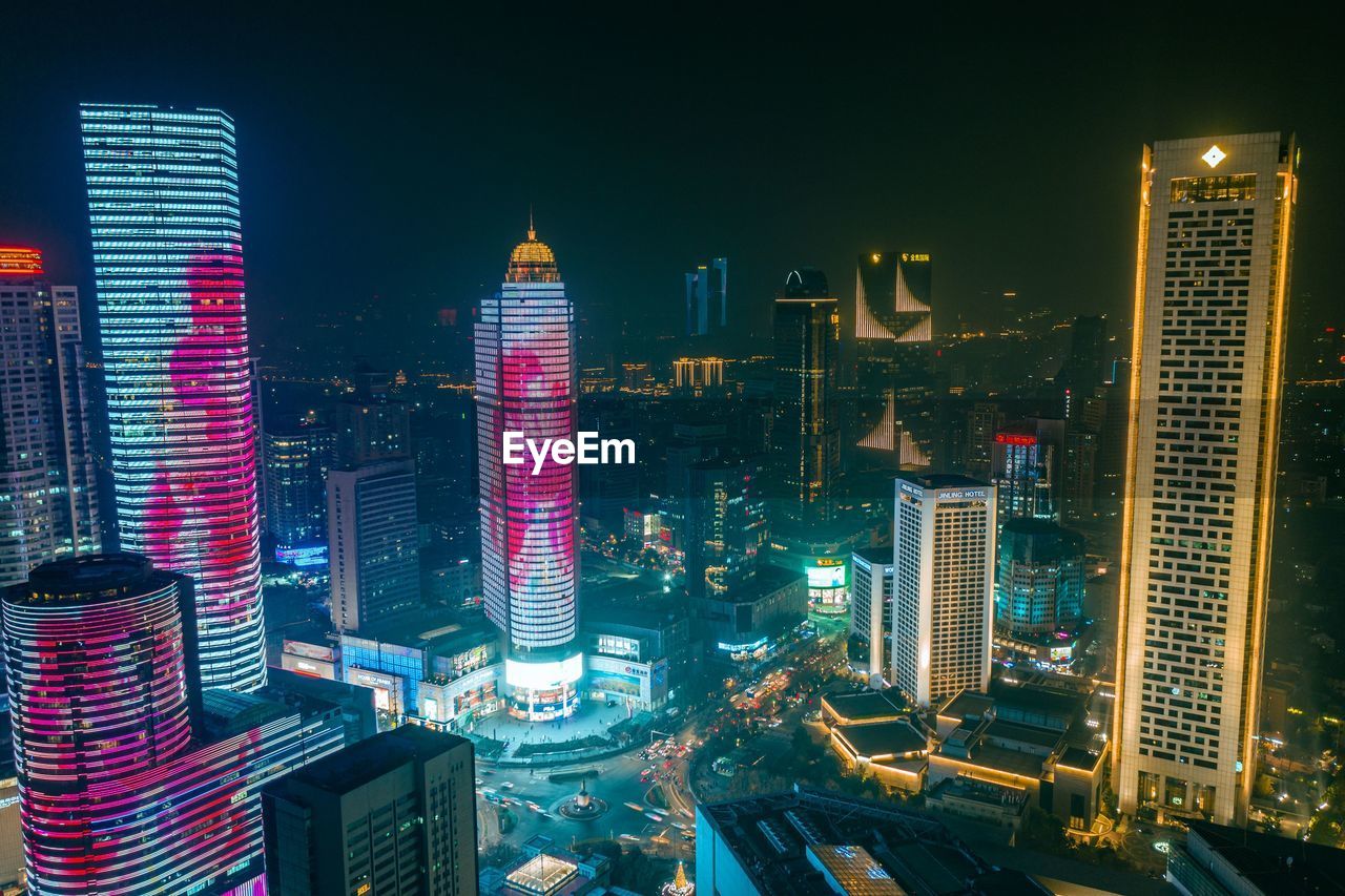 ILLUMINATED BUILDINGS IN CITY AT NIGHT