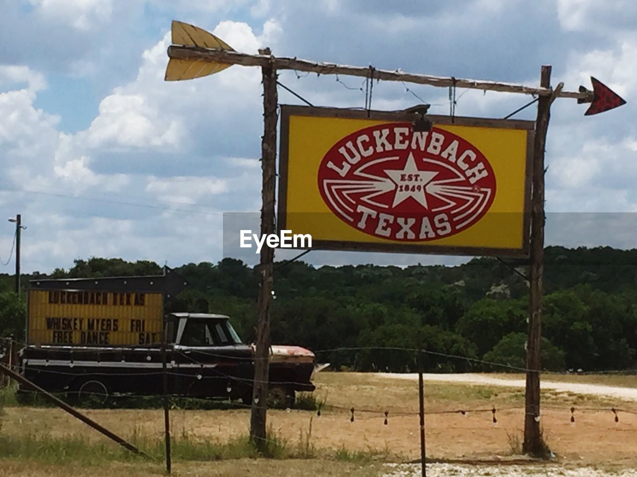 INFORMATION SIGN HANGING ON YELLOW AGAINST SKY