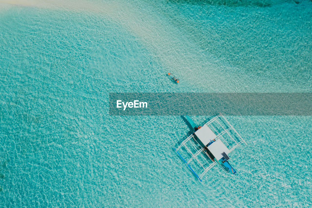 Drone view of man kayaking in sea on sunny day