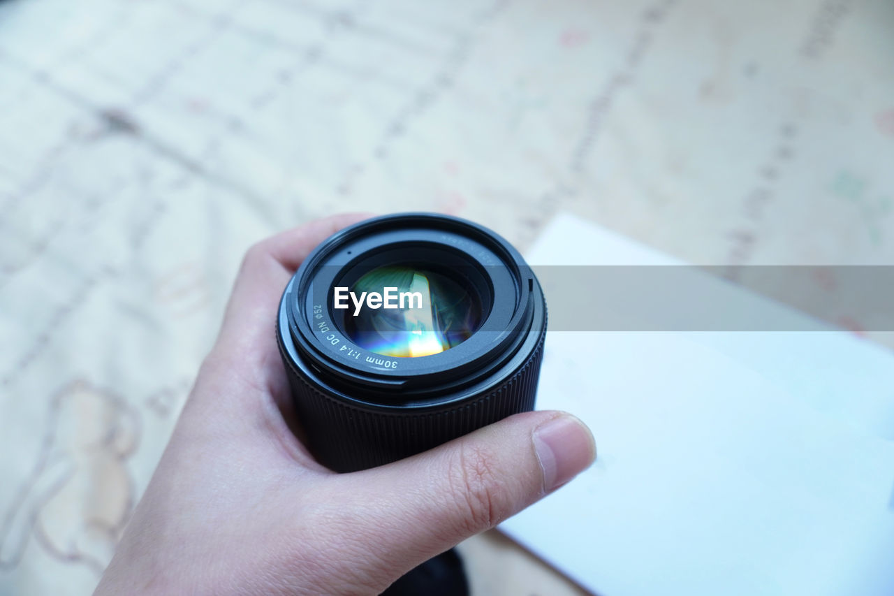 Close-up of hand holding camera lens