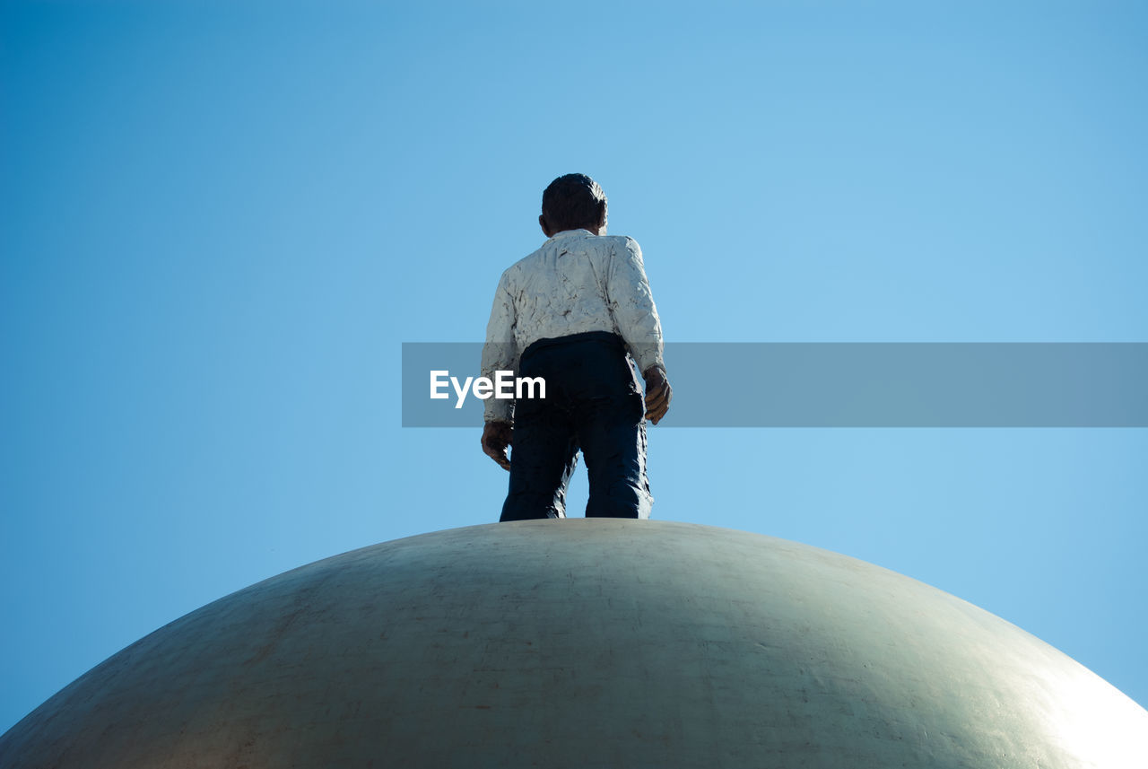 Low angle view of statue against clear blue sky