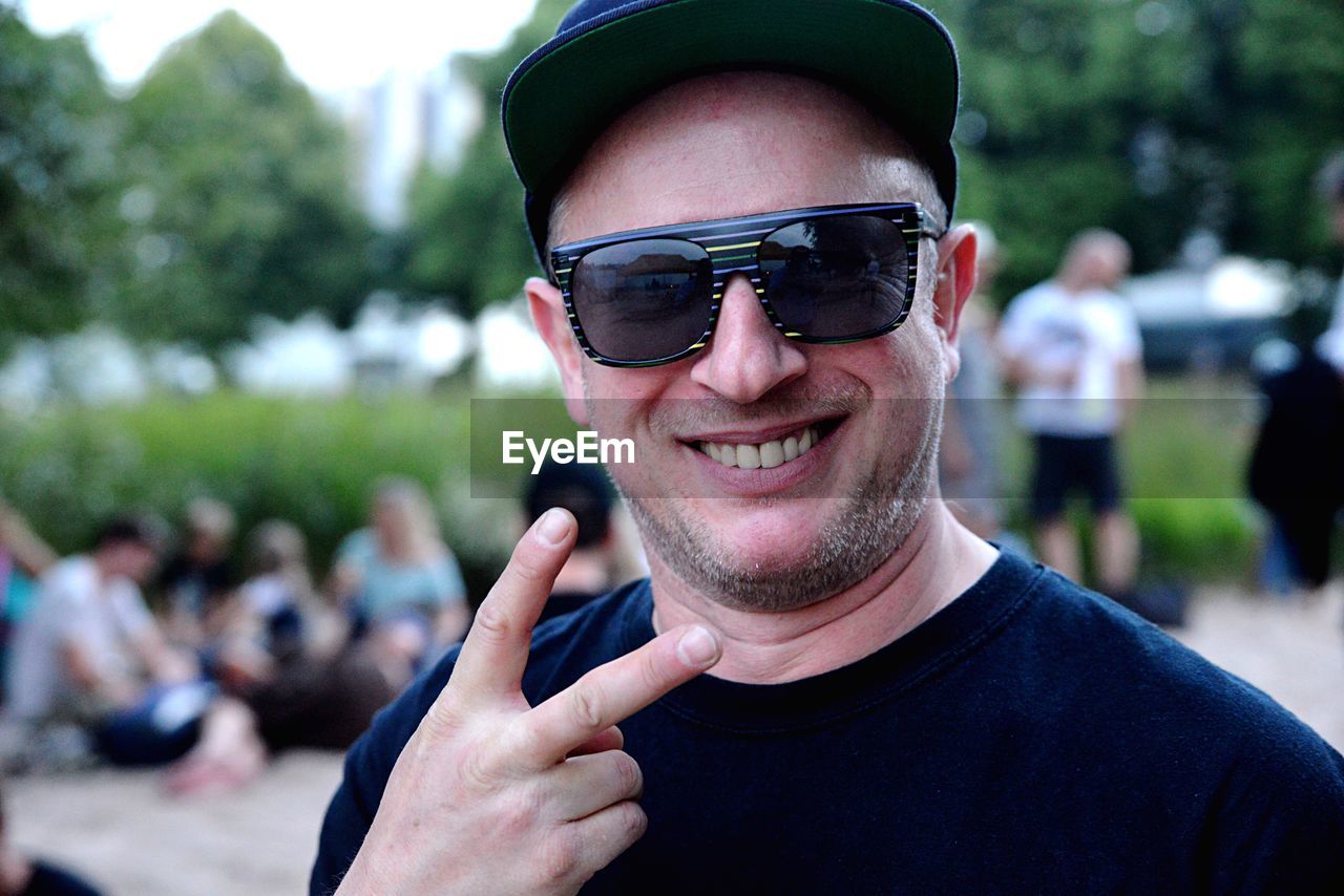 Portrait of smiling man showing peace sign