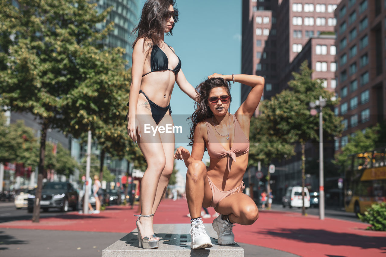 Fashionable young women wearing bikinis in city