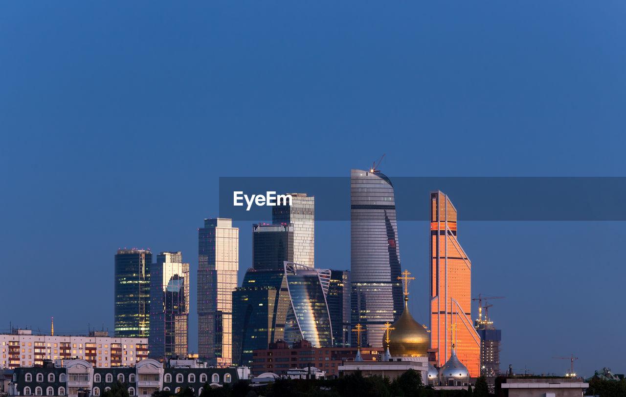 MODERN BUILDINGS IN CITY AGAINST BLUE SKY