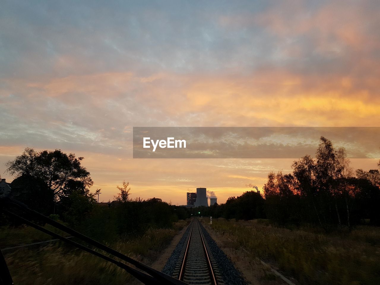 RAILROAD TRACK AGAINST SKY DURING SUNSET