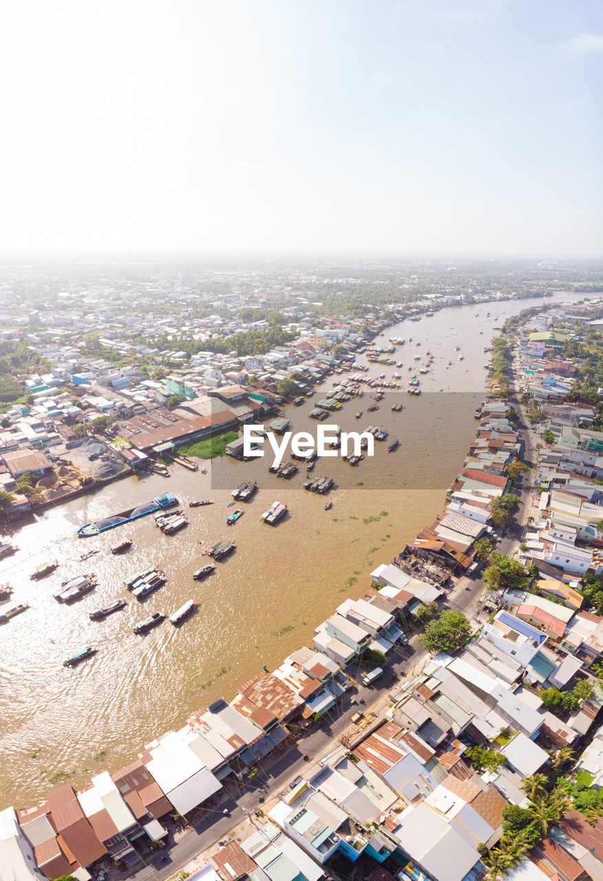 HIGH ANGLE VIEW OF TOWN BY SEA AGAINST SKY