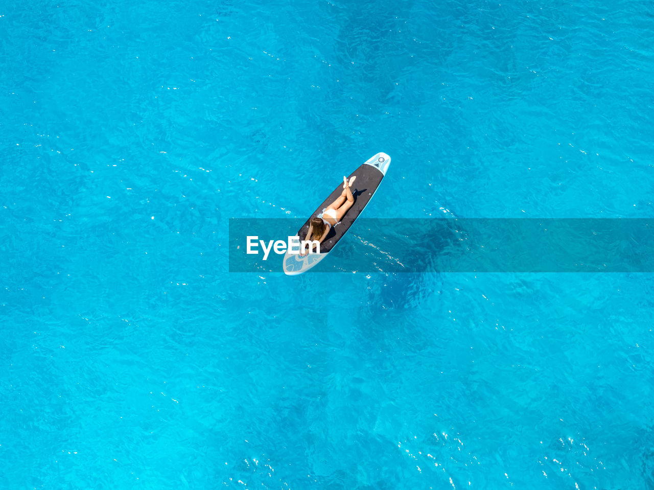 HIGH ANGLE VIEW OF MAN SWIMMING IN POOL