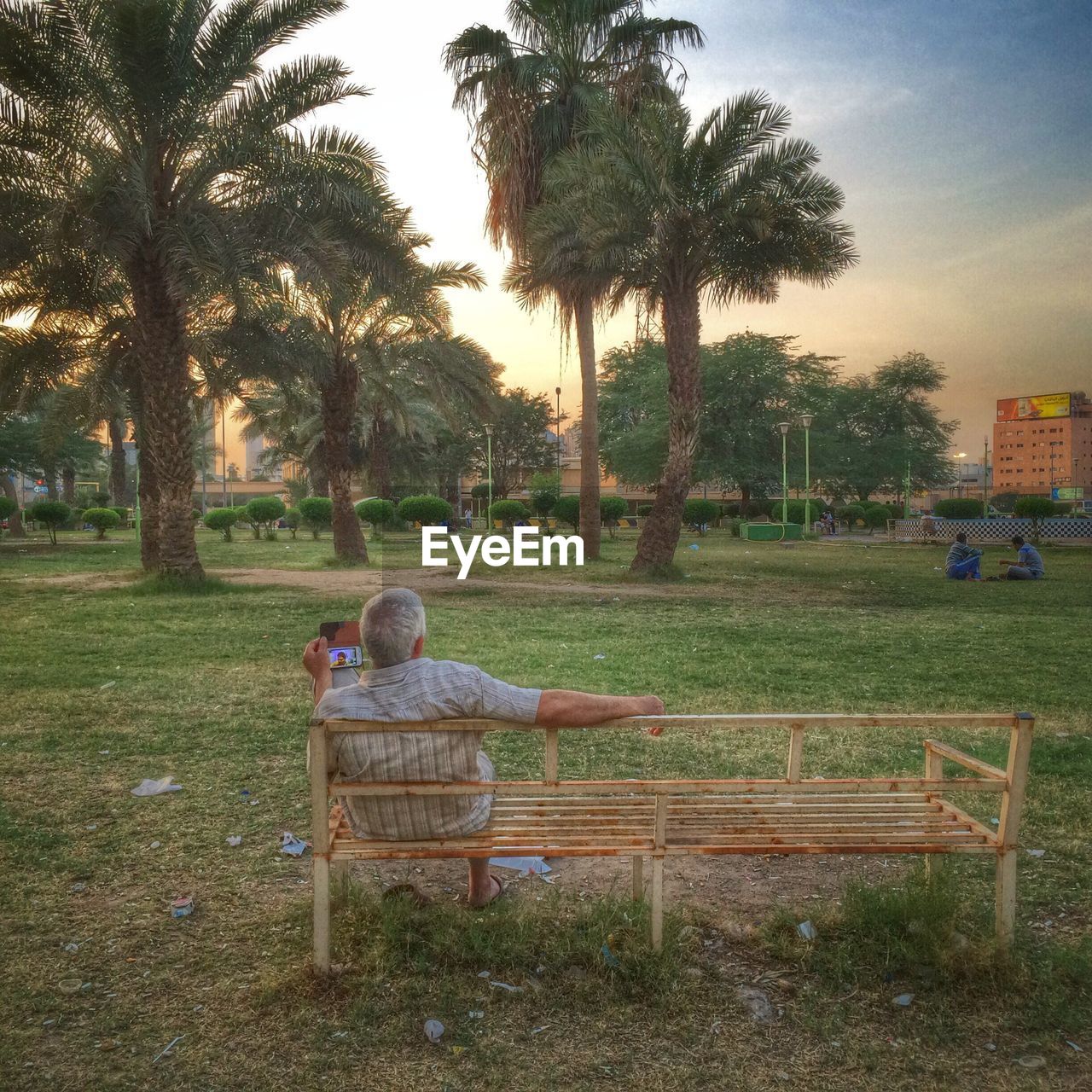 PEOPLE SITTING ON BENCH IN PARK