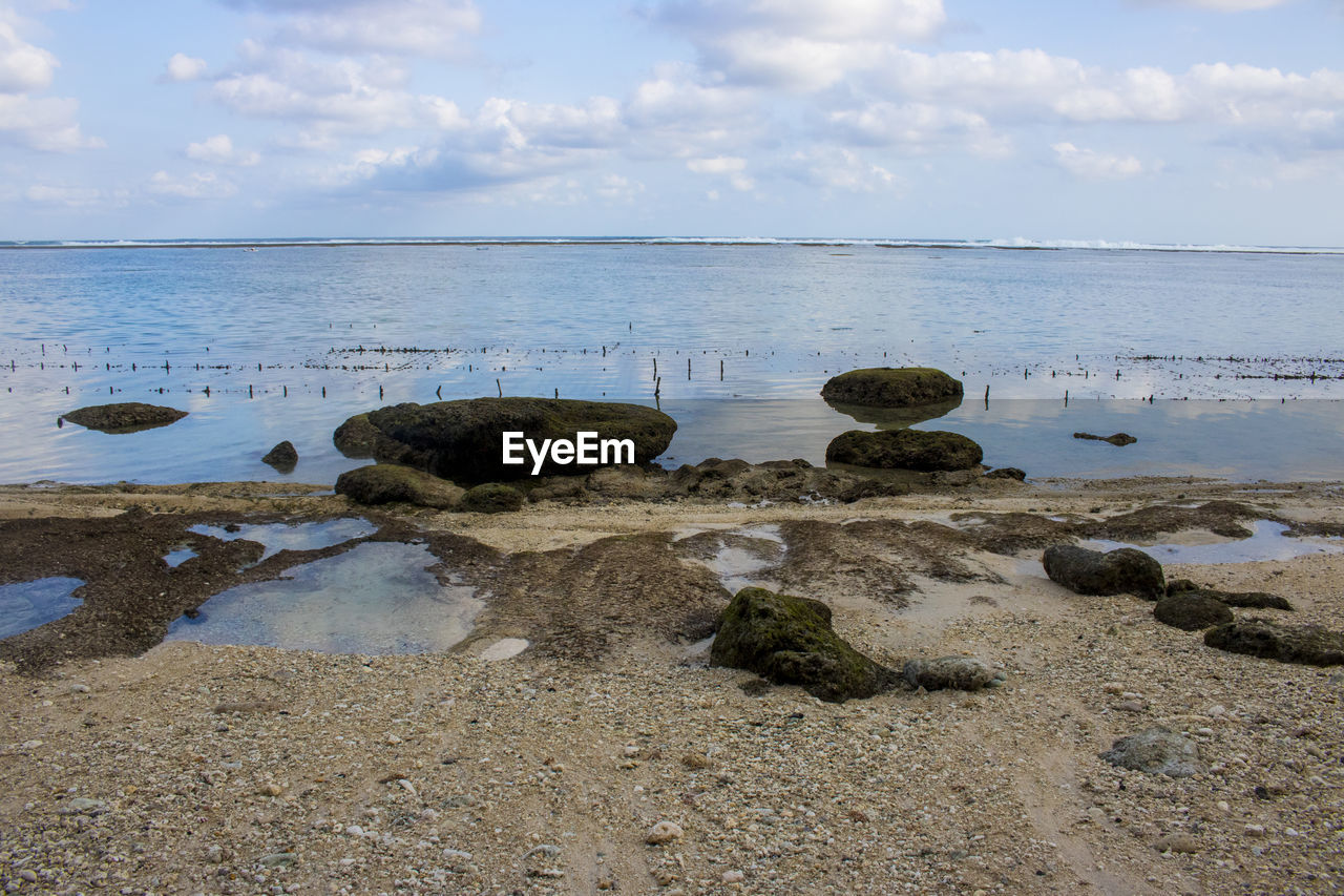 ROCKS ON BEACH AGAINST SKY
