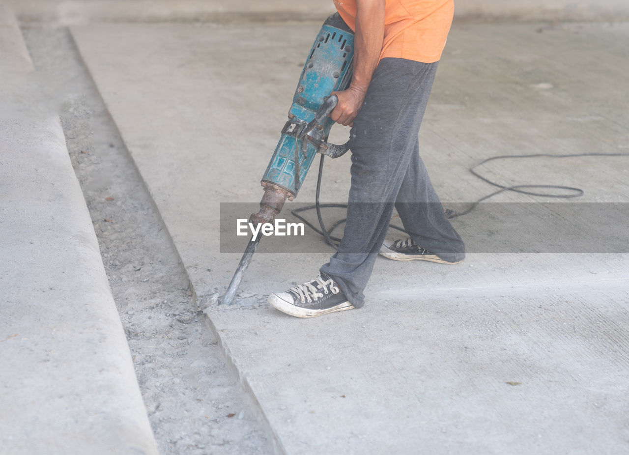 low section of man walking on road