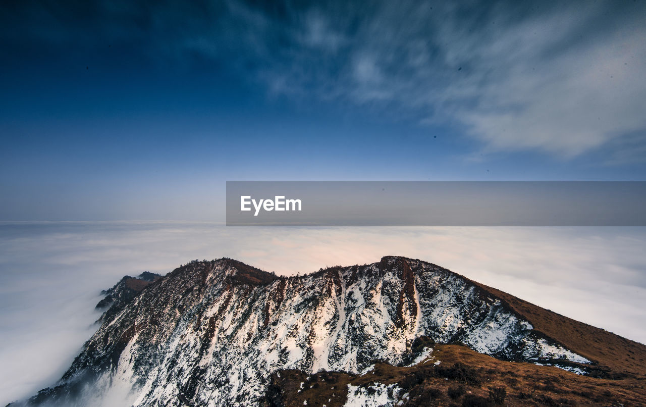 Scenic view of snowcapped mountain and cloudscape against sky