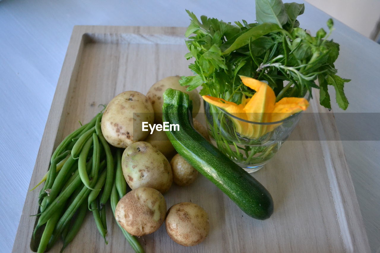 food and drink, food, healthy eating, vegetable, wellbeing, freshness, produce, root vegetable, high angle view, no people, indoors, green, raw food, organic, herb, carrot, raw potato, dish, still life, wood, ingredient, fruit, onion, plant, container, zucchini, table, cutting board, cucumber, spice, variation