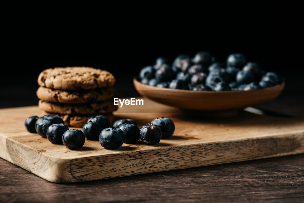 Blueberry and cookies on wooden board