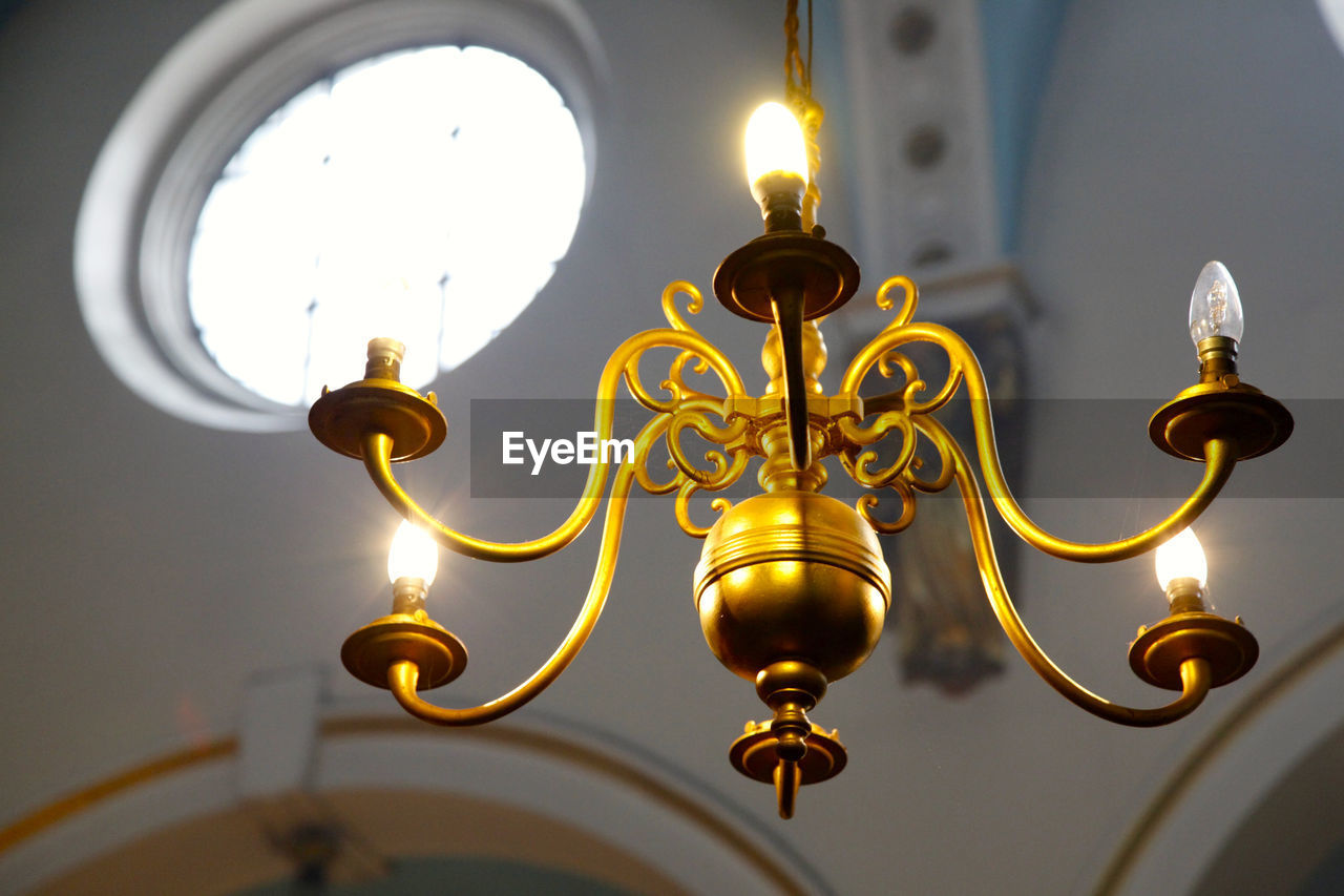 Low angle view of lit chandelier in church