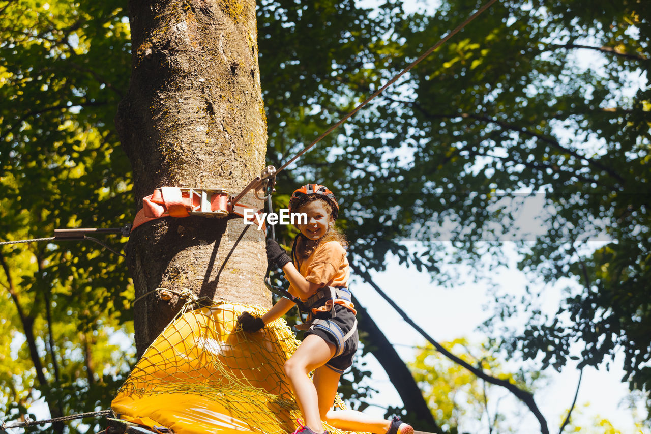 low angle view of woman sitting on tree
