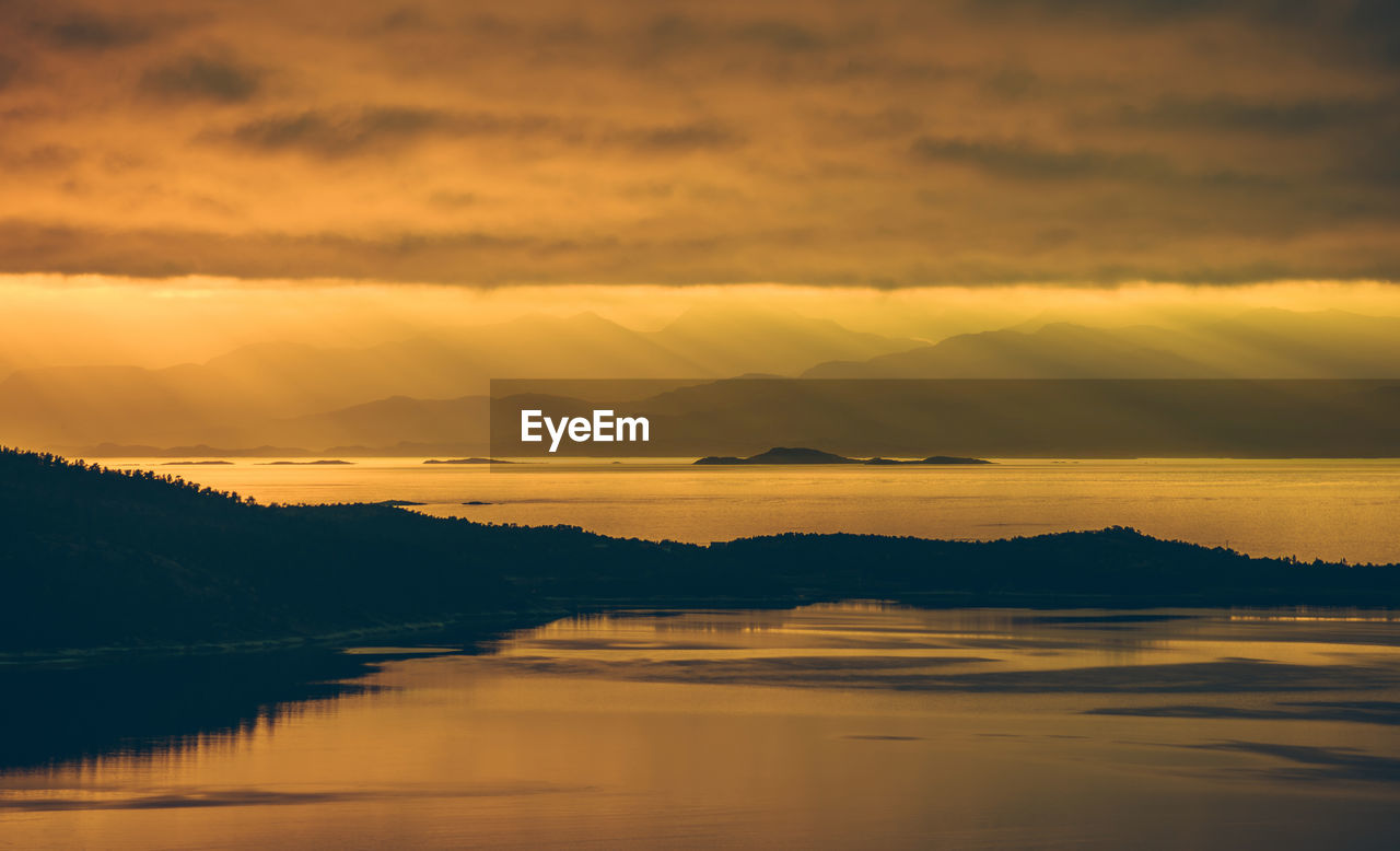 SCENIC VIEW OF LAKE AGAINST ORANGE SKY DURING SUNSET