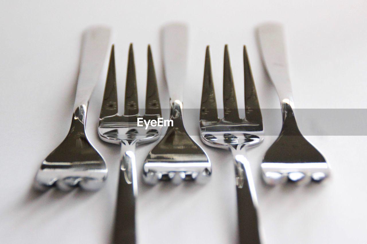 Close-up of forks arranged on gray background