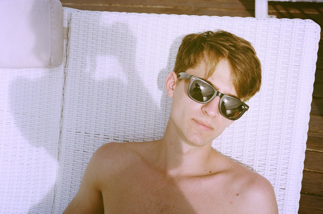 Portrait of shirtless man wearing sunglasses