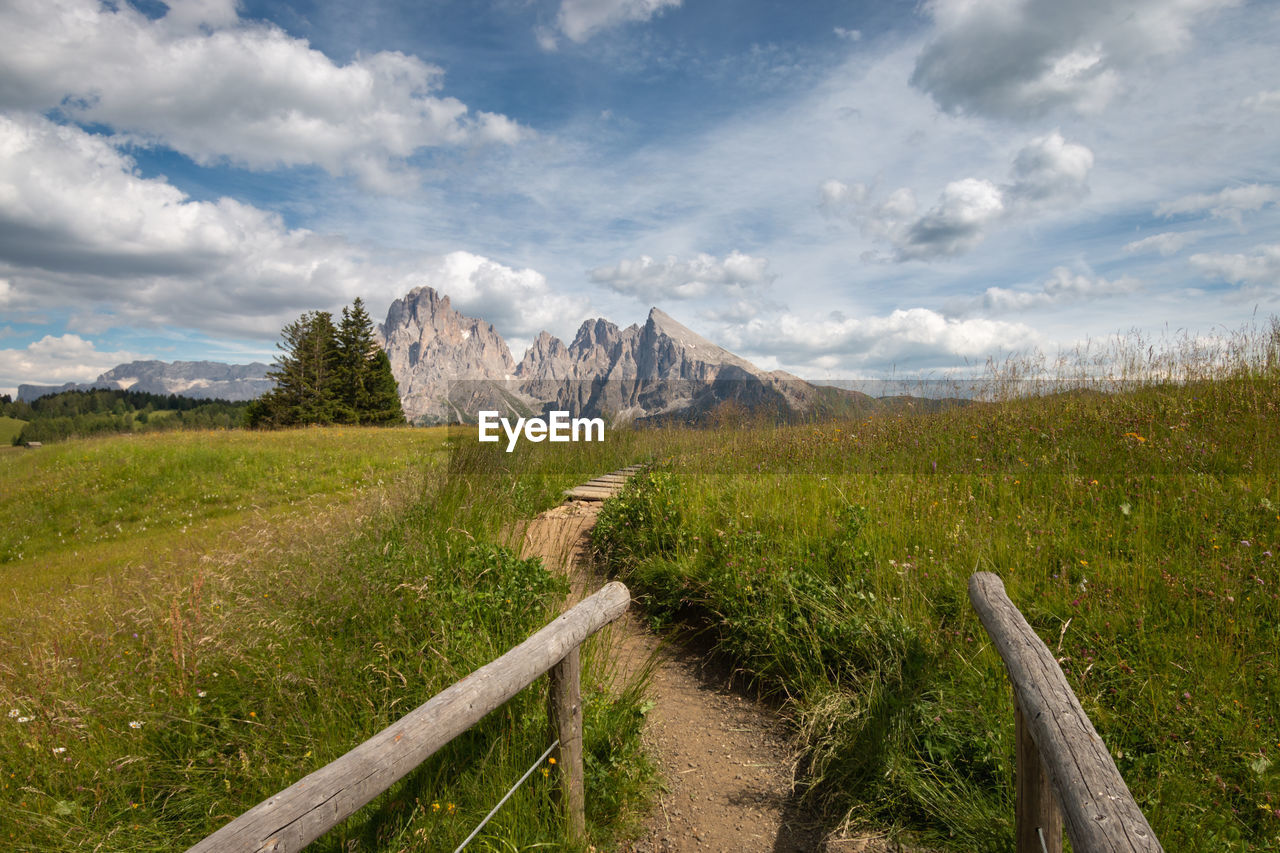 Scenic view of hiking trail with mountains at seiser alm against sky