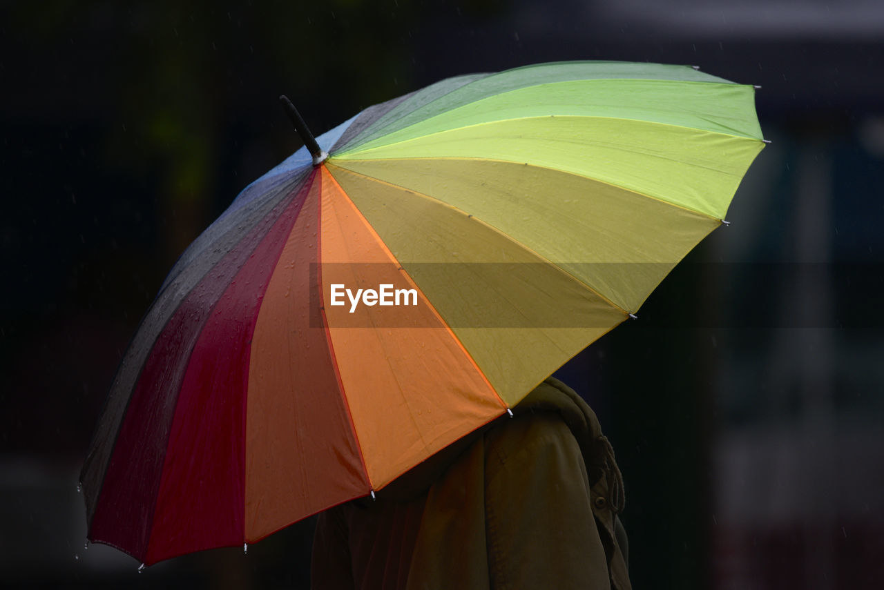 Person holding multicolored umbrella