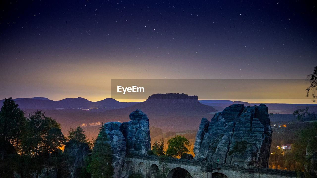 Scenic view of mountains against sky at night