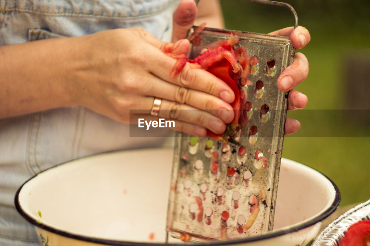 CLOSE-UP OF HAND HOLDING ICE CREAM IN PLATE