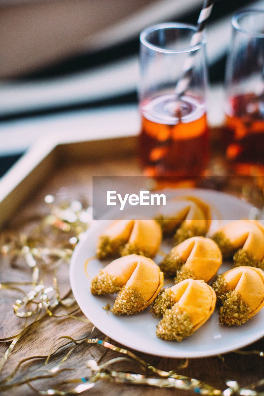 Close-up of fortune cookies and drink in tray on table