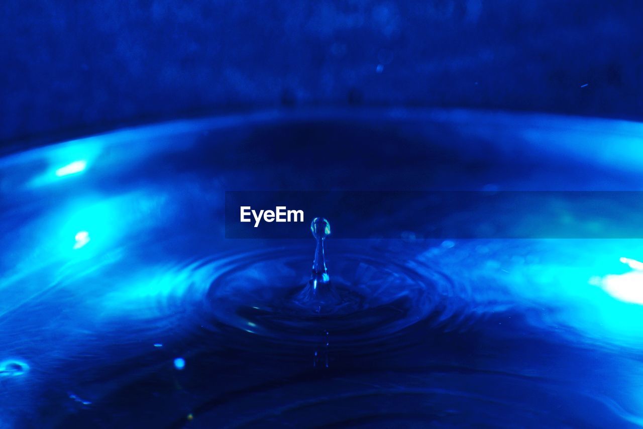 CLOSE-UP OF DROP FALLING ON WATER SURFACE