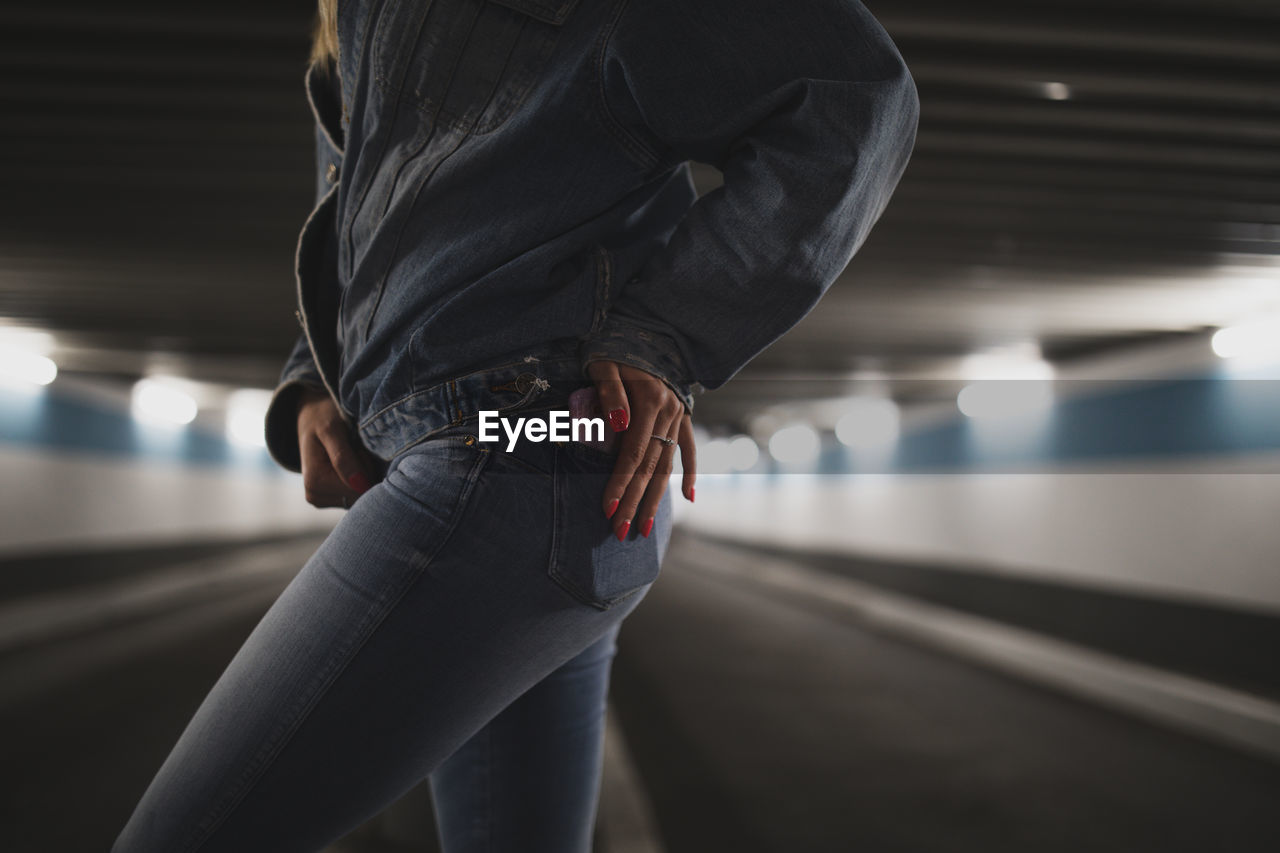 Midsection of woman walking at subway station