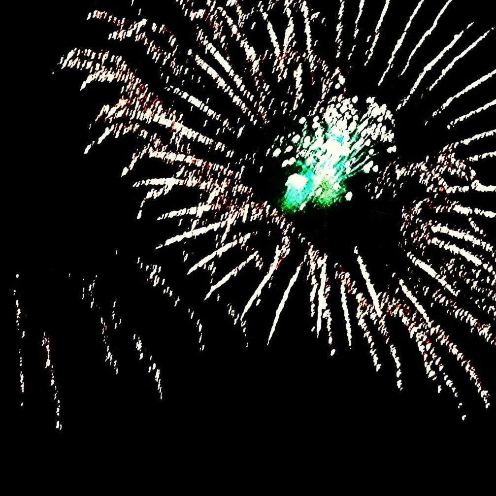 LOW ANGLE VIEW OF FIREWORK DISPLAY AT NIGHT