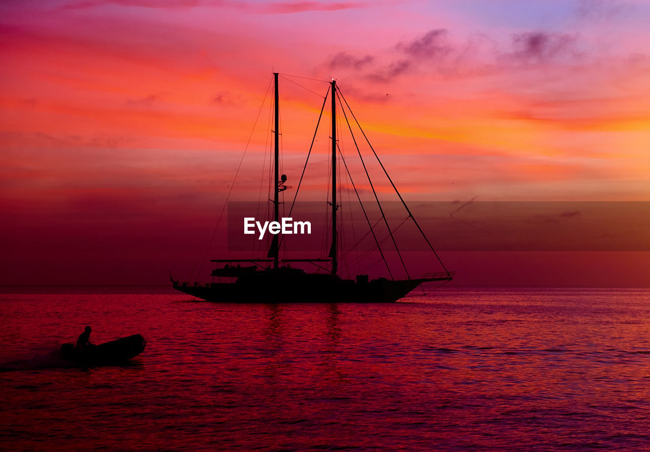 Ship sailing in sea against sky during sunset