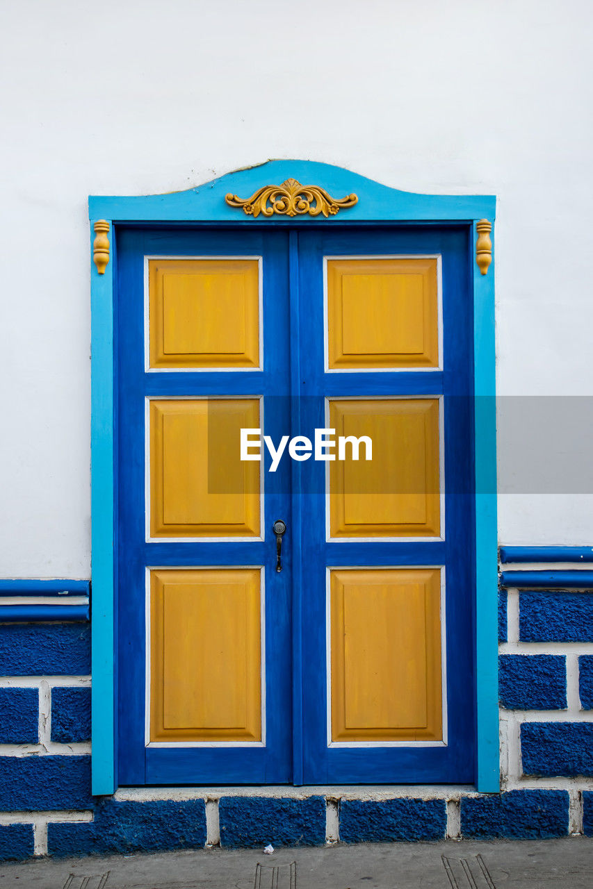 blue, architecture, door, entrance, building exterior, built structure, no people, closed, yellow, wood, building, protection, wall - building feature, security, day, city, communication, outdoors, furniture, house, facade, multi colored