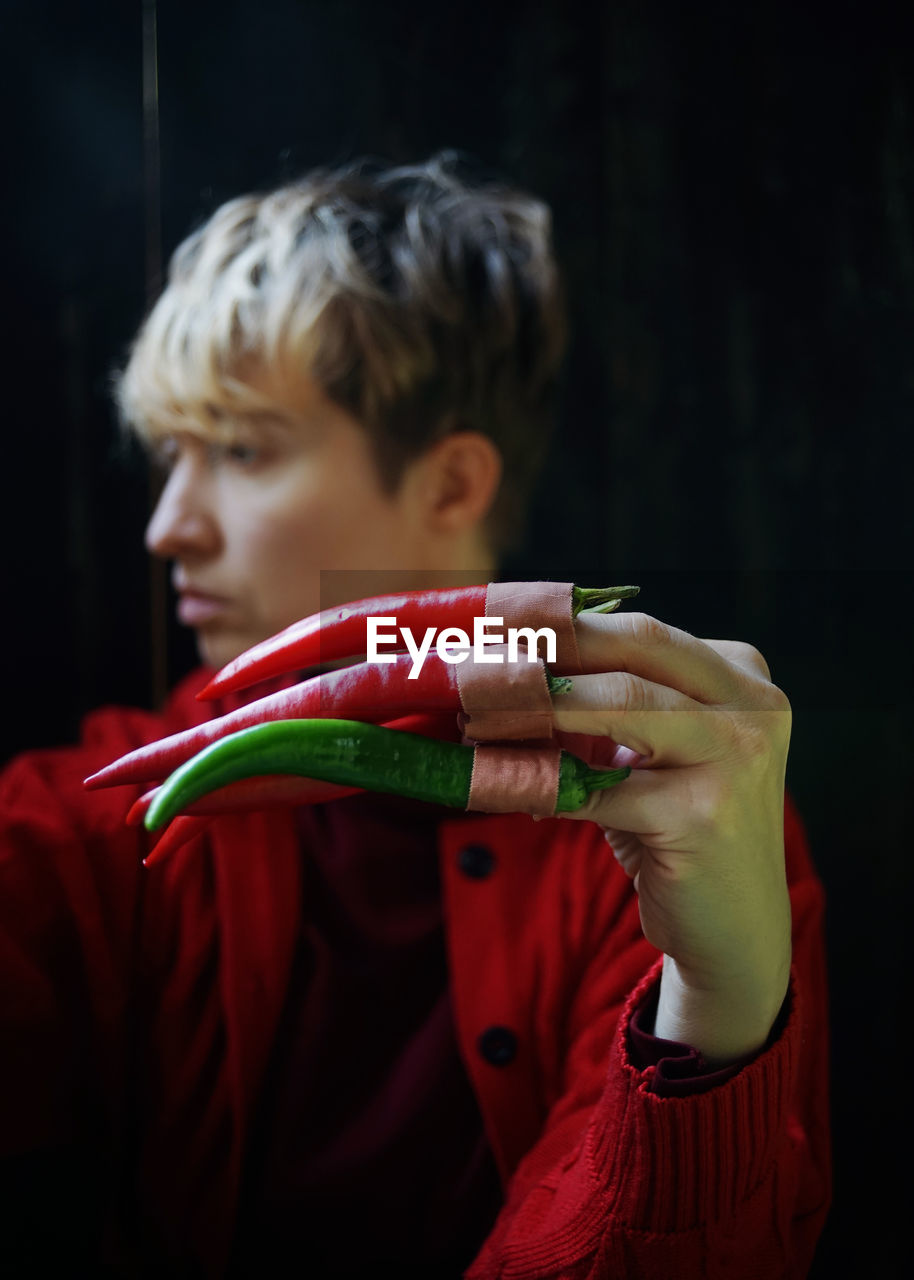 PORTRAIT OF MAN HOLDING RED CHILI