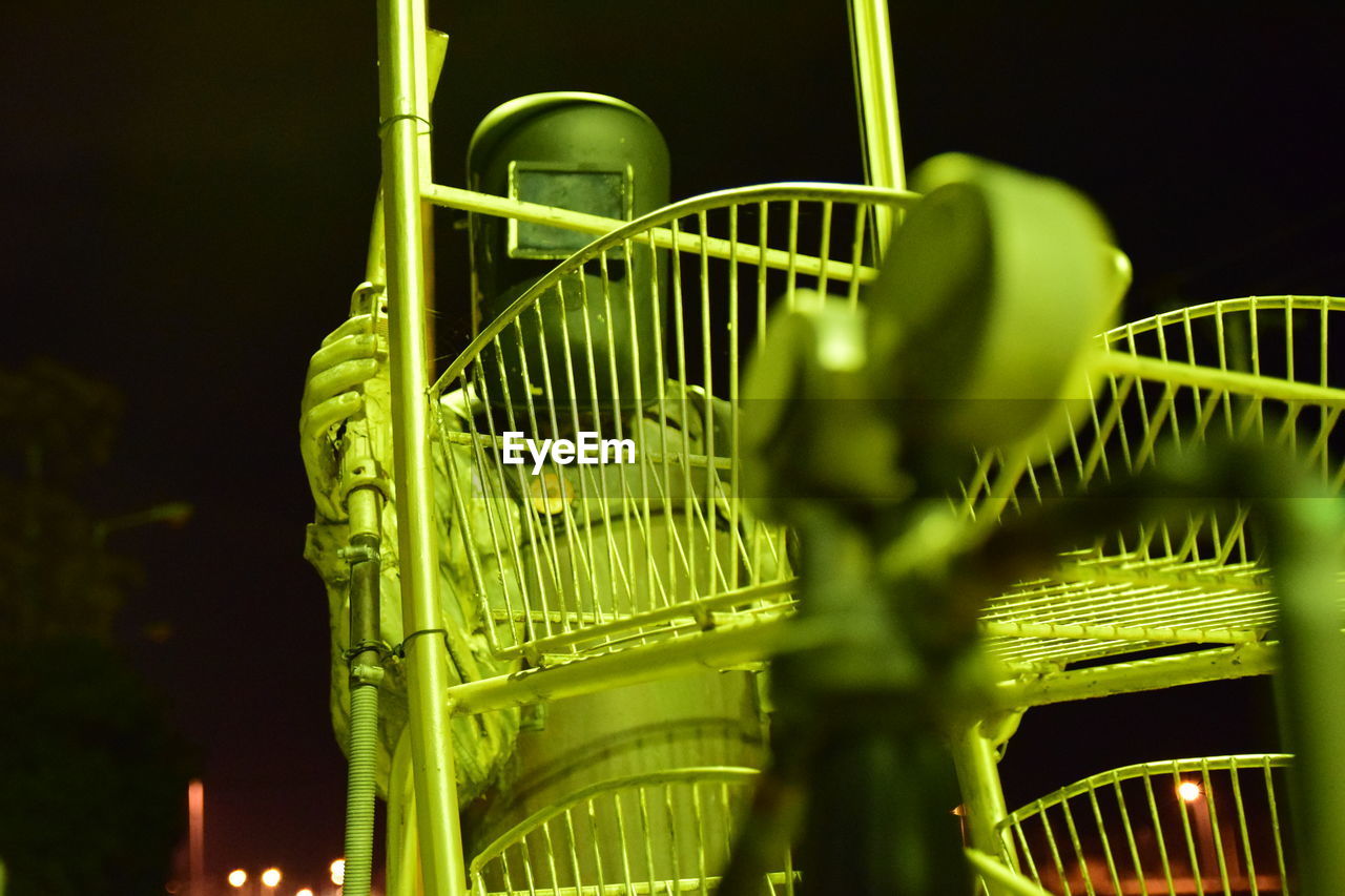 Close-up of person in uniform standing by machinery in factory