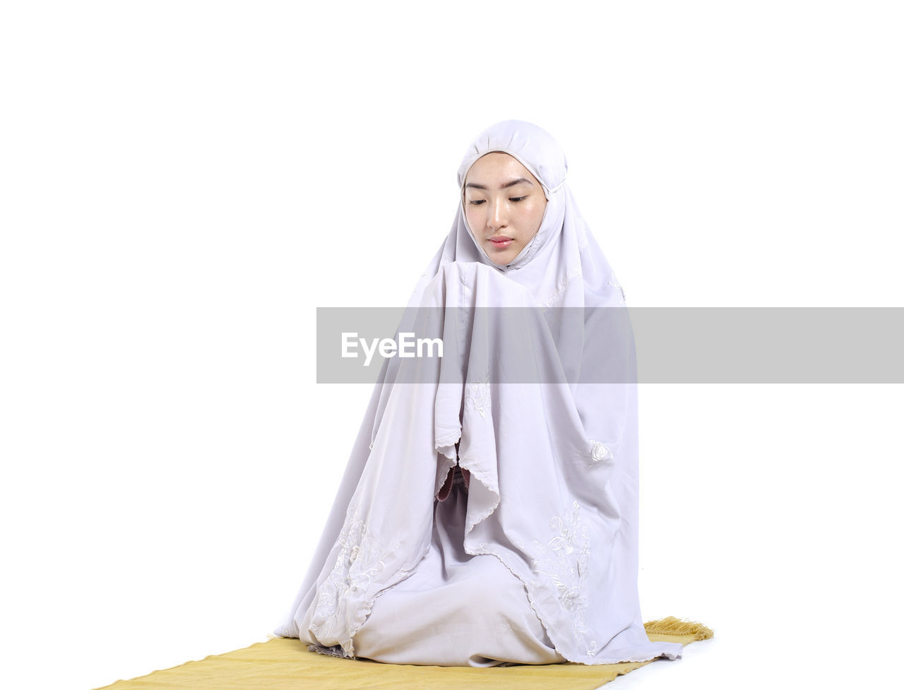 WOMAN STANDING AGAINST WHITE BACKGROUND