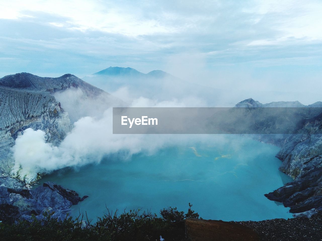 Smoke emitting from volcanic mountain against sky