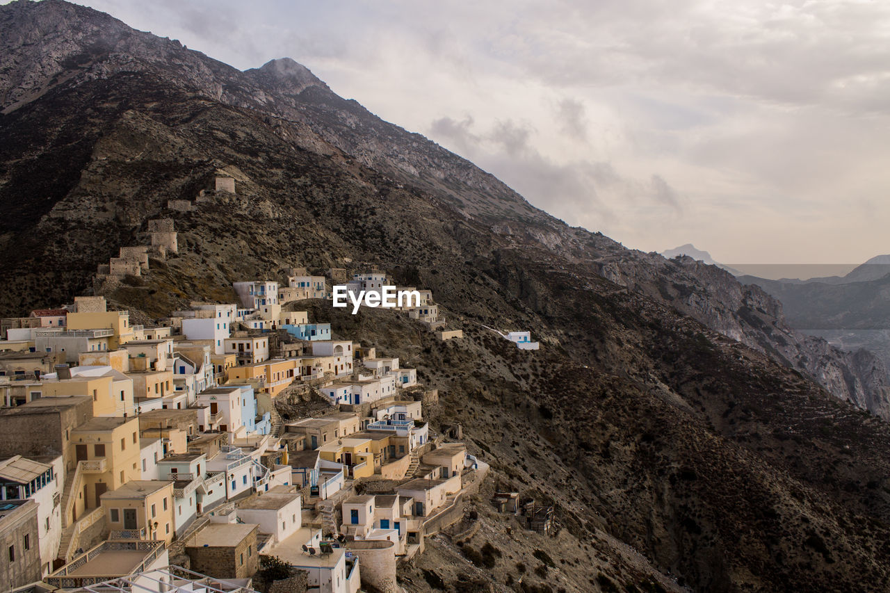 Houses on mountain against sky 